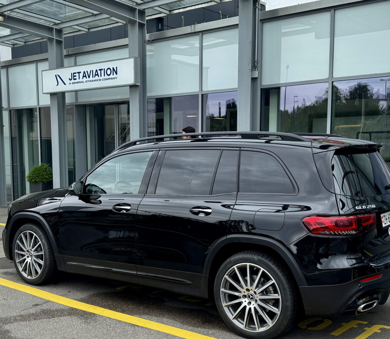 Globetransporte Mercedes GLB black car picking up 3 private jet crew from Jet Aviation at Zurich Airport for VIP transfer to Interlaken.
