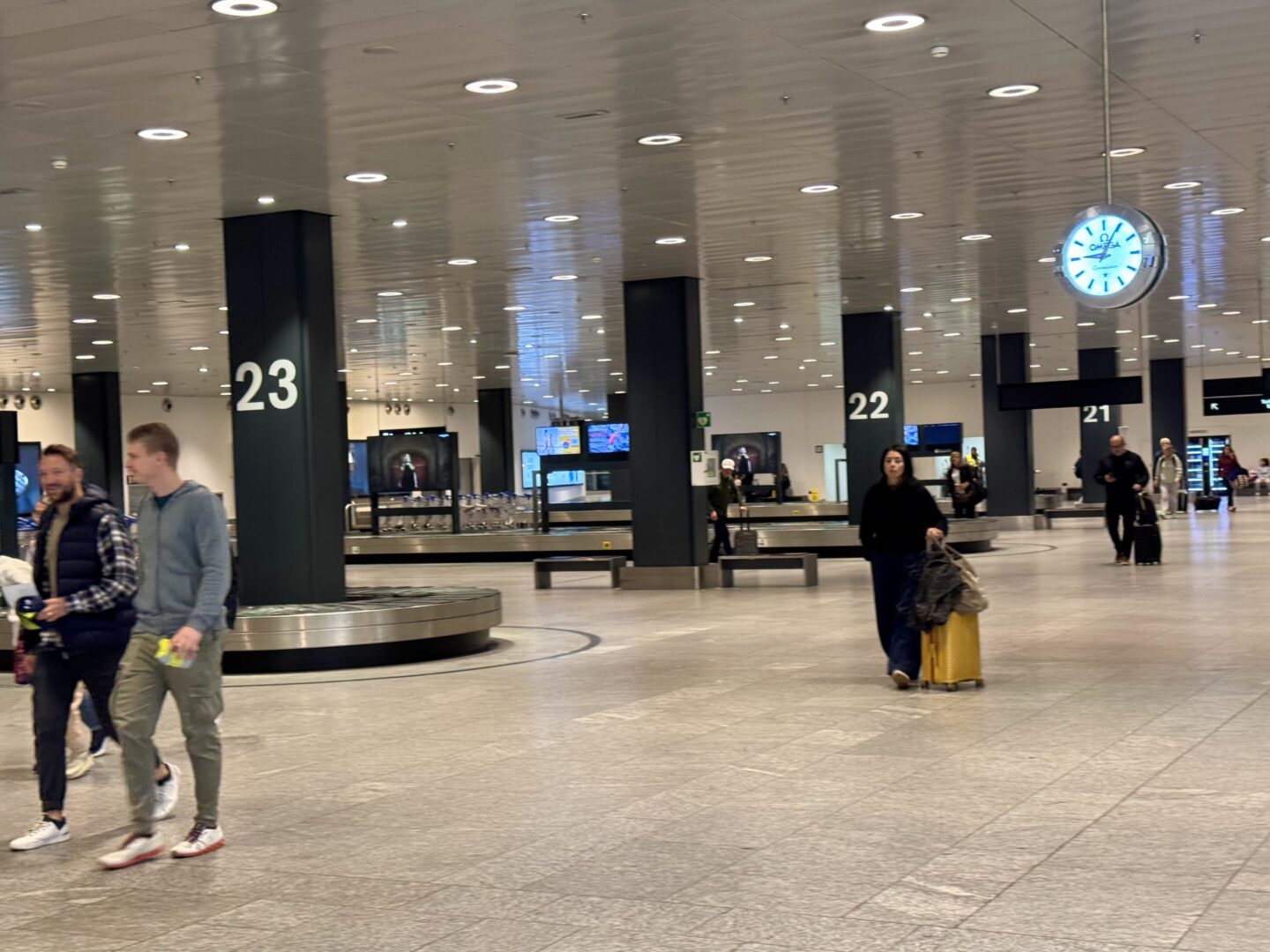 Globetransporte chauffeur helping passengers with luggage at Zurich Airport and guiding them to the waiting car at the terminal exit.