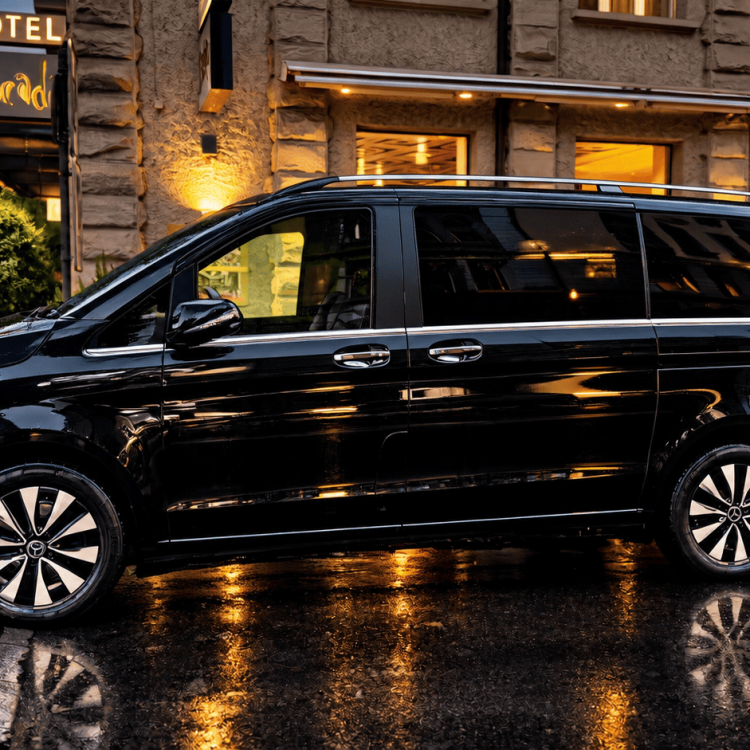 Dark grey Mercedes-Benz V 300 luxury chauffeur van parked outside Hotel Cascada in Lucerne, Switzerland.