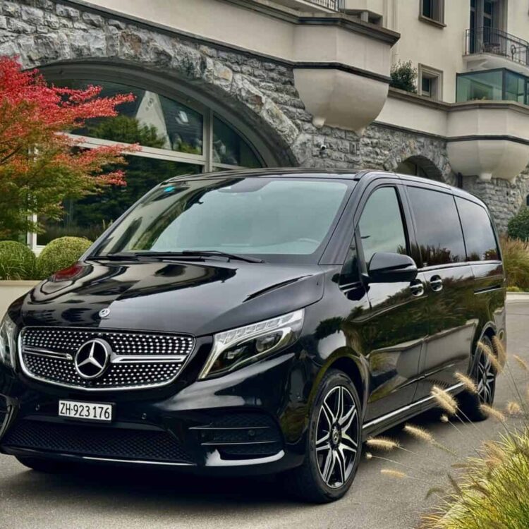Luxury Mercedes-Benz V-Class van parked in an urban setting with modern buildings in the background.