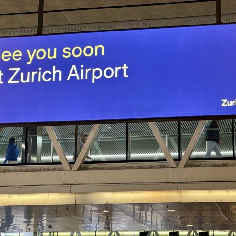 Zurich Airport departure gate with the iconic “See you soon” sign — captured by Globetransporte chauffeur service.