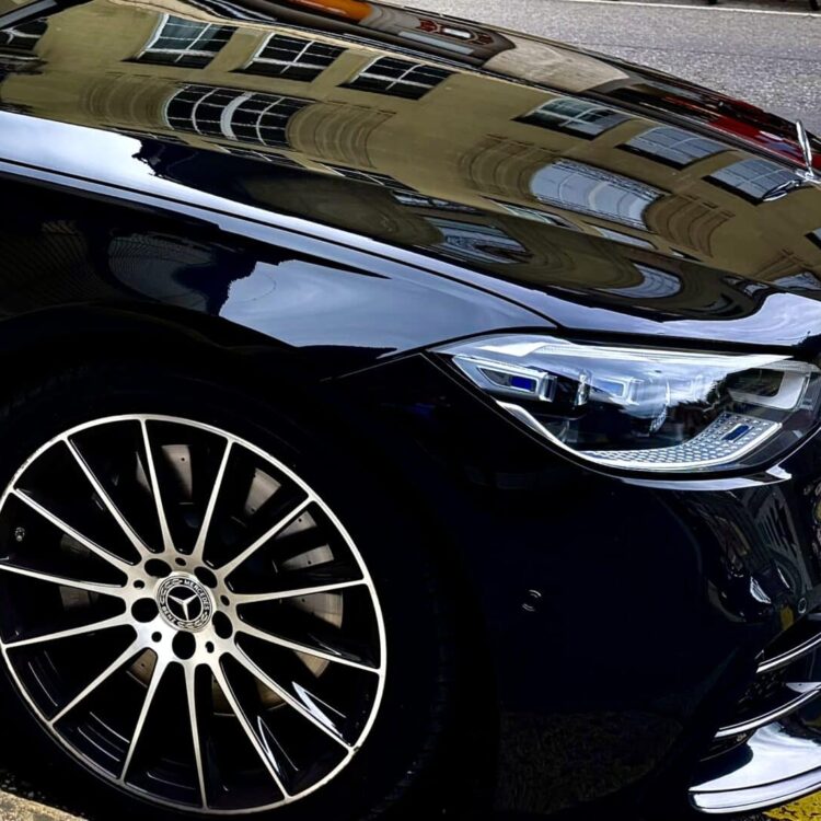 Luxury black Mercedes-Benz vehicle parked on the street, showcasing its sleek design and stylish alloy wheel. Perfect for professional transportation and chauffeur services.